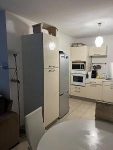 a kitchen with a refrigerator and a table in a room at Le Coton Verde , 2 nuits minimum in Sainte-Rose