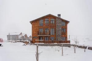 a house with two people on top of it in the snow at Chalet In Gudauri in Gudauri