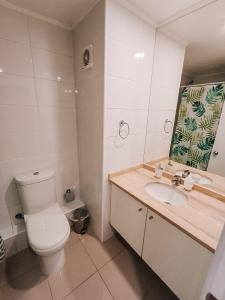 a bathroom with a toilet and a sink and a mirror at Departamento en Calama in Calama