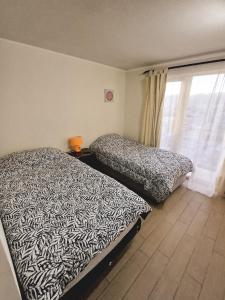 a bedroom with two beds and a window at Departamento en Calama in Calama
