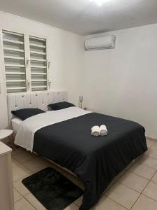 1 dormitorio con 1 cama con 2 toallas en Le Coton Verde - proches plages en Sainte-Rose