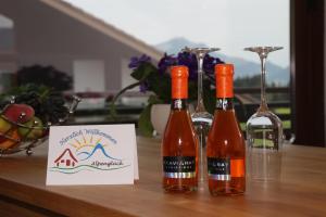 drei Flaschen Wein auf einem Tisch mit einem Schild in der Unterkunft Ferienwohnung "Alpenglück" mit Hallenbad in Bolsterlang