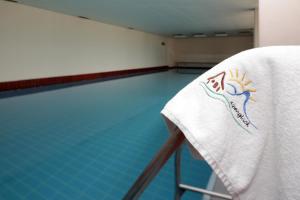 ボルシュターラングにあるFerienwohnung "Alpenglück" mit Hallenbadのスイミングプールの隣の椅子にタオル