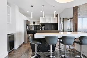 a kitchen with a white counter and gray chairs at LUXURY PENTHOUSE ON THE BEACH 3/3 OCEANFRONT CONDO in Hollywood