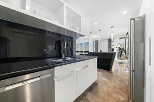 a kitchen with white cabinets and a stainless steel refrigerator at LUXURY PENTHOUSE ON THE BEACH 3/3 OCEANFRONT CONDO in Hollywood