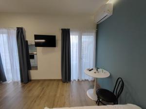 a living room with a table and chairs and a television at Pritania 2 in Komotini