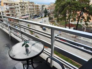 a table and chair on a balcony with a view of a city at Pritania 2 in Komotini