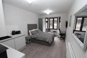 um quarto com uma cama e uma cozinha com um lavatório em New Cosy Studio in London! em Londres
