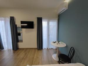 a living room with a table and chairs and a television at Pritania 2 in Komotini
