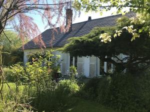 una casa blanca con techo negro en Metrie, en Sauqueville