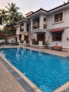 a house with a swimming pool in front of a house at Coastal Suites Apartment Hotel ---- 8 minutes walk to beach in Benaulim