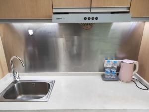 a kitchen counter with a sink and a microwave at Yangzhou Xianyun Apartment in Yangzhou