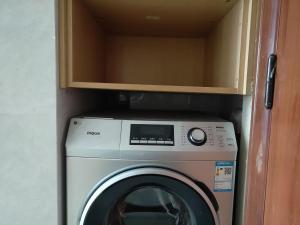 a washer and dryer in a small room at Yangzhou Xianyun Apartment in Yangzhou