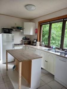 a kitchen with white cabinets and a wooden counter top at Chalet - l'Endoxyle in Froid-Chapelle