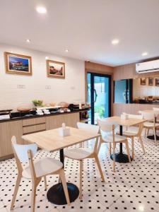 a restaurant with tables and chairs in a kitchen at Nakara Hotel, Ubon Ratchathani in Ban Na Kham