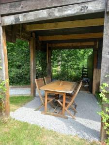 a wooden table and chairs sitting under a pavilion at Chalet - l'Endoxyle in Froid-Chapelle