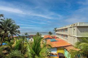 Blick auf ein Resort mit Palmen und einem Gebäude in der Unterkunft Roseal Water Front in Baga