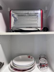 2 scaffali di un frigorifero con piatti e tostapane di Splendours Condos@Jesselton Quay a Kota Kinabalu