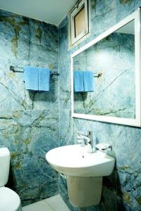 uma casa de banho com um lavatório e um espelho em Conord Hotel - "Amman's Heart" em Amã