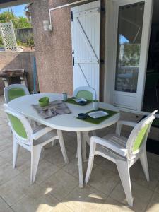 einen weißen Tisch und Stühle auf einer Terrasse in der Unterkunft Appartement T2 Olmeto in Olmeto