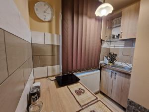 a small kitchen with a clock on the wall at Ana Studio in Hunedoara +7 photos
