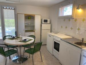 eine Küche mit einem Tisch, einem Tisch und Stühlen in der Unterkunft Appartement T2 Olmeto in Olmeto