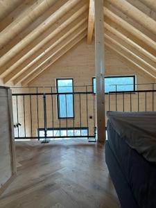 a attic room with a bed and two windows at Ferienhaus am Sommerberg in Vöhrenbach