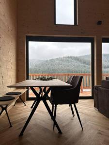 a dining room with a table and a large window at Ferienhaus am Sommerberg in Vöhrenbach