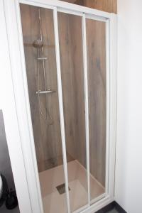 a shower with a glass door in a bathroom at Appart Hotel Coutances in Coutances
