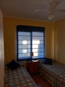 1 dormitorio con 2 camas y ventana en Apartamento Voramar Primera Linea de Mar, en El Campello