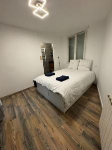 1 dormitorio con 1 cama grande y suelo de madera en Appartement cosy, en Roussillon en Isère