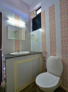 a bathroom with a white toilet and a sink at The View Munnar in Anachal