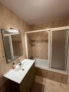 ein Badezimmer mit einem Waschbecken, einem Spiegel und einer Badewanne in der Unterkunft Centro de Comillas in Comillas