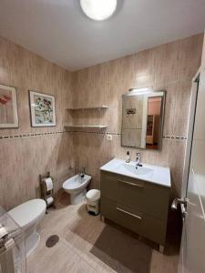 ein Badezimmer mit einem Waschbecken, einem WC und einem Spiegel in der Unterkunft Centro de Comillas in Comillas