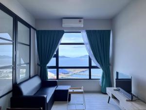 - un salon avec un canapé et une grande fenêtre dans l'établissement Splendours Condos@Jesselton Quay, à Kota Kinabalu