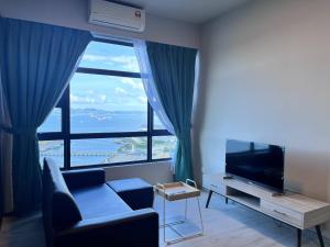 a living room with a couch and a large window at Splendours Condos@Jesselton Quay in Kota Kinabalu