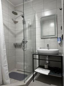 a bathroom with a sink and a glass shower at Mayster Home in Chernivtsi