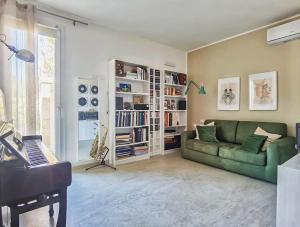 - un salon avec un canapé vert et un piano dans l'établissement La Sarina Luxury near Gallipoli, à Matino