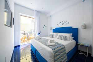 um quarto azul e branco com uma cama e uma janela em 4blu Camere Marine em Maiori