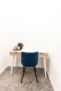 a desk with a blue chair in front of a wall at Suite 3 - Stunning Room in Oldham Sociable House in Oldham