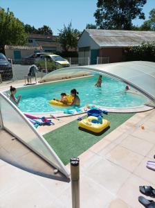 eine Gruppe von Menschen, die in einem Schwimmbad spielen in der Unterkunft Logis de LANGE apt les Ecureuils in Saint-Hilaire-la-Palud