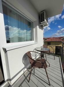d'une terrasse avec 2 chaises et une table sur un balcon. dans l'établissement Comfort & Luxury Apartaments PNMresidence, à Timişoara