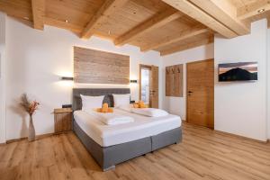 a bedroom with a large bed and a wooden ceiling at Apart Stiegler in Stumm
