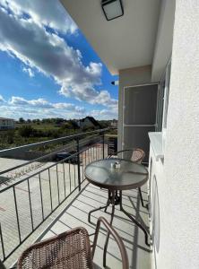 d'une terrasse avec une table et des chaises sur un balcon. dans l'établissement Comfort & Luxury Apartaments PNMresidence, à Timişoara