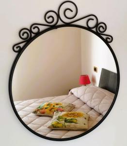einen Spiegel, der ein Bett im Schlafzimmer reflektiert in der Unterkunft I GIRASOLI Short Rent in Palermo