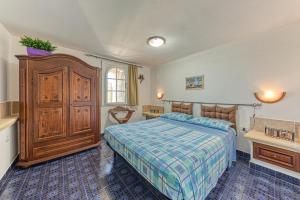 Schlafzimmer mit einem Bett und einem Holzschrank in der Unterkunft Salento seaside apartment with sea view and garden in Torre Pali 