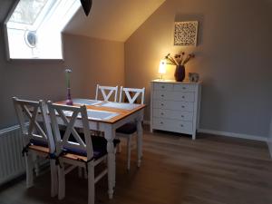 comedor con mesa, sillas y vestidor en Ferienwohnung Haloi, en Torsballig