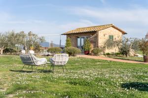 two chairs sitting in the grass in front of a house at Glamping Diacceroni in Villamagna