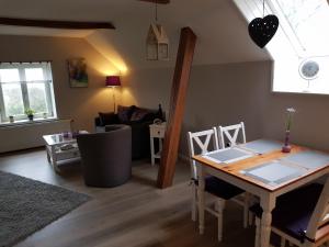 una sala de estar con una mesa y un sofá en Ferienwohnung Haloi, en Torsballig