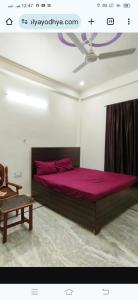 a bedroom with a large bed with purple sheets at राम जानकी भवन होम स्टे in Faizābād